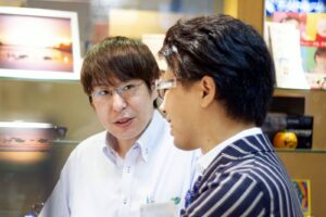 メガネのタナカヤ南新町本店でスタッフとメガネについて相談する様子
