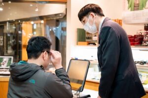 店頭で遠近両用メガネの見え方を確かめるお客様とスタッフ